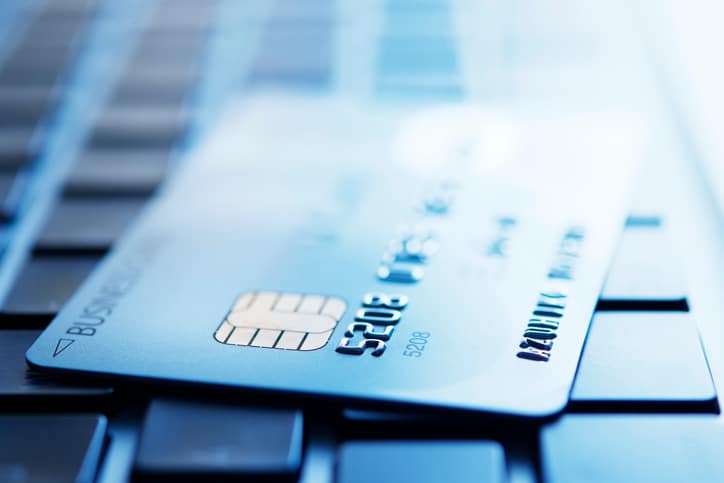 Blue tinted image of credit card on laptop with shallow depth of field.